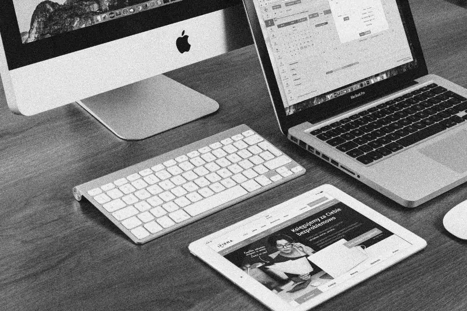 Multiple devices on a desk being used to create a responsive website.